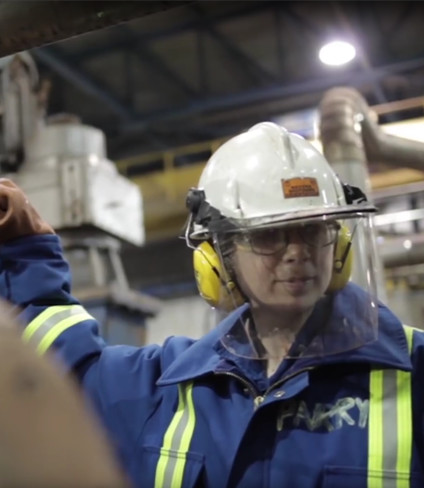 Photo of Hudbay employee in a hard hat and wearing ear protection