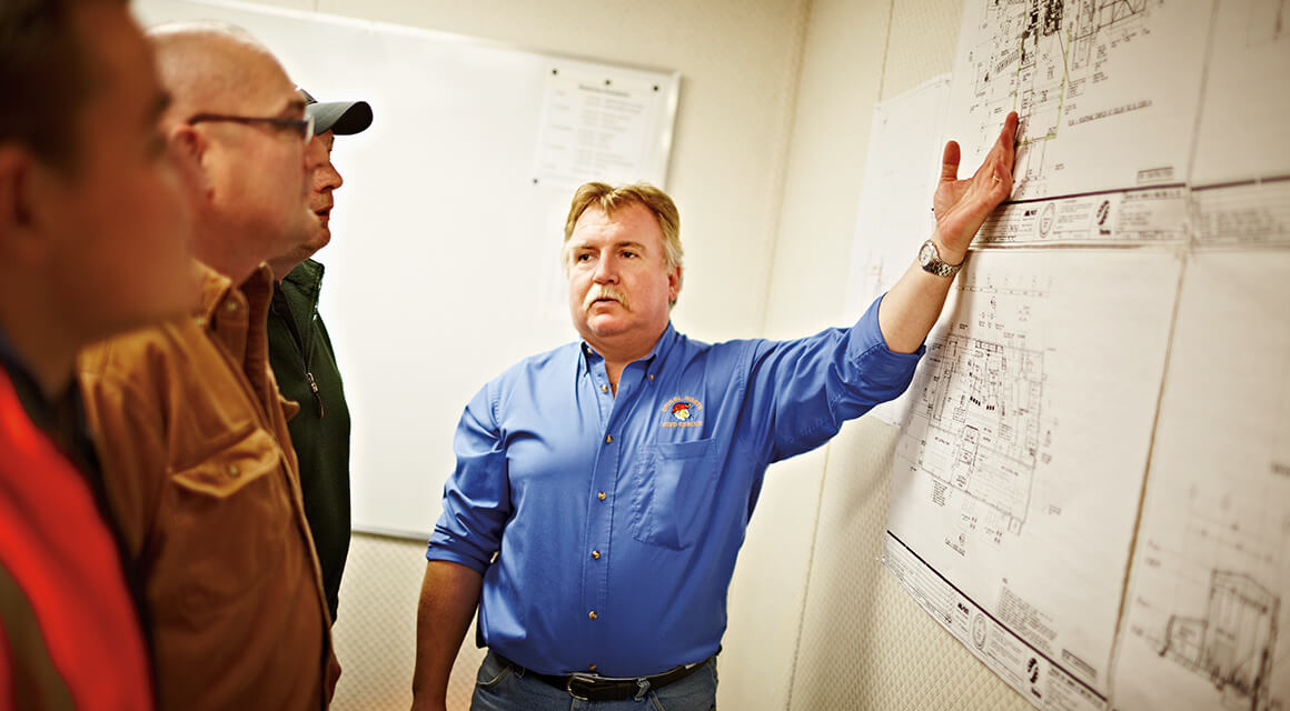 Employees looking at detailed plans on a wall